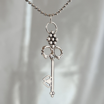 Men's Sterling Silver Skull Key Necklace on durable ball chain suspended with ethereal backdrop