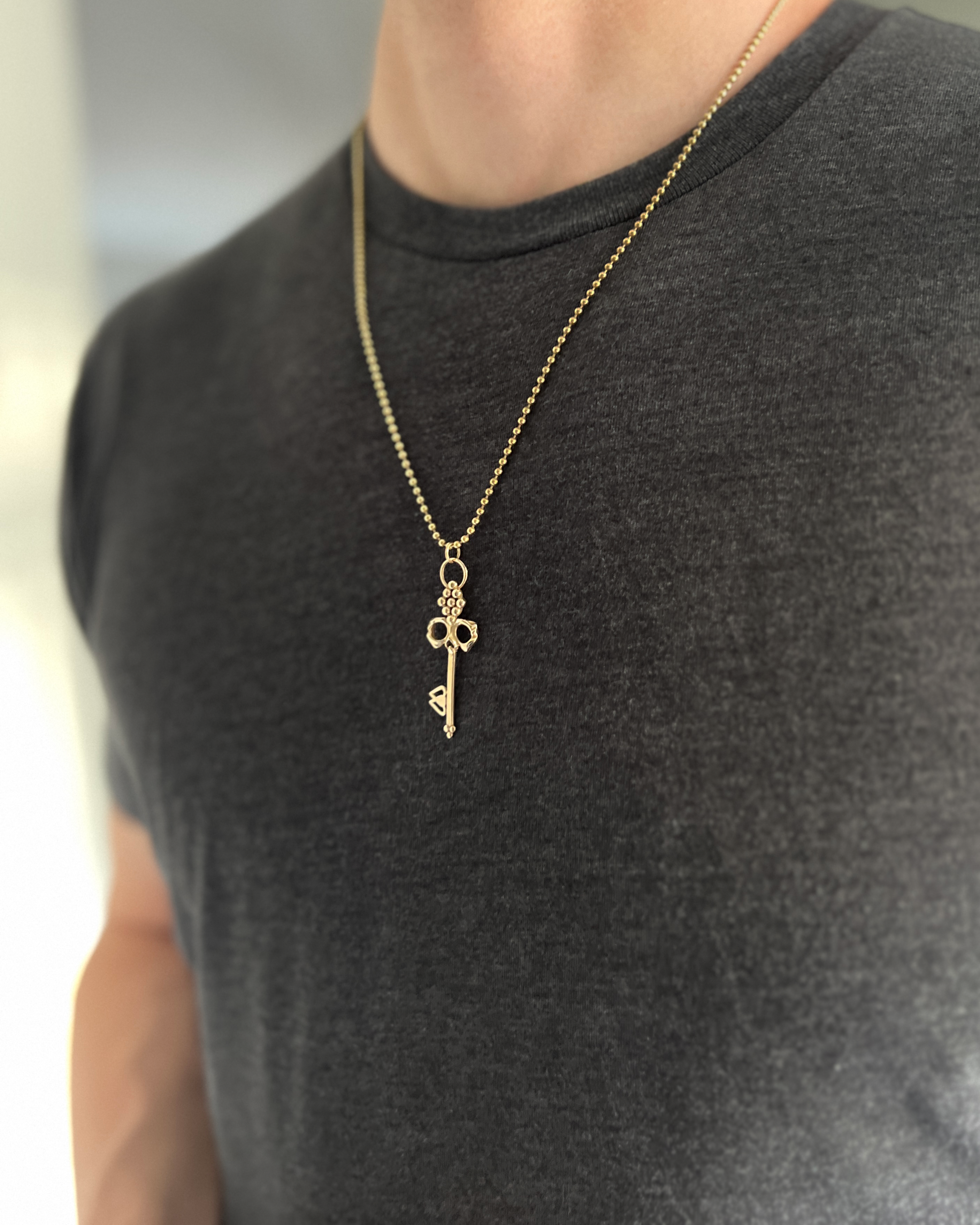 Men's Brass Skull Key Necklace hung from durable ball chain worn on neck