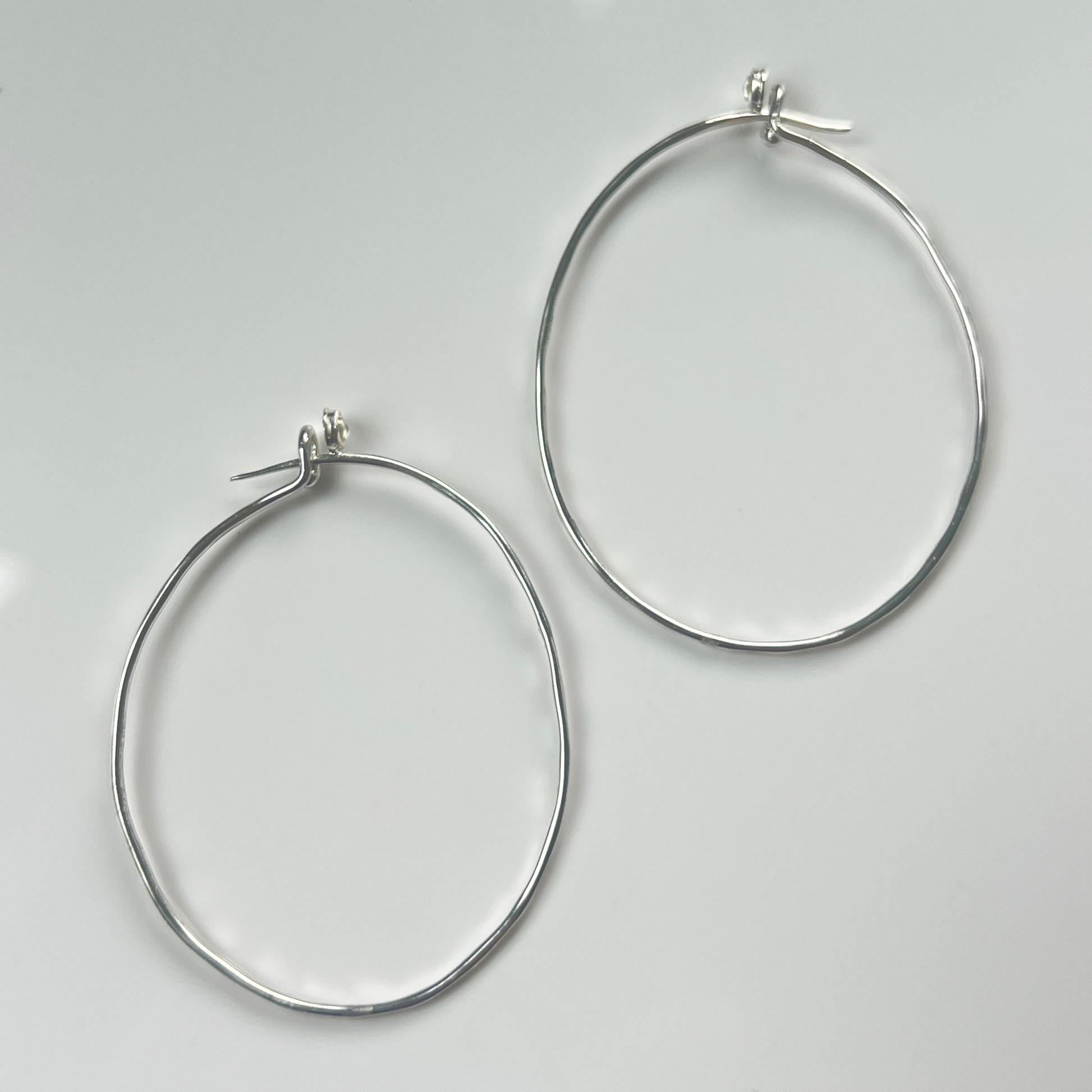 Flatlay of Silver Hammered Hoops with White Topaz 