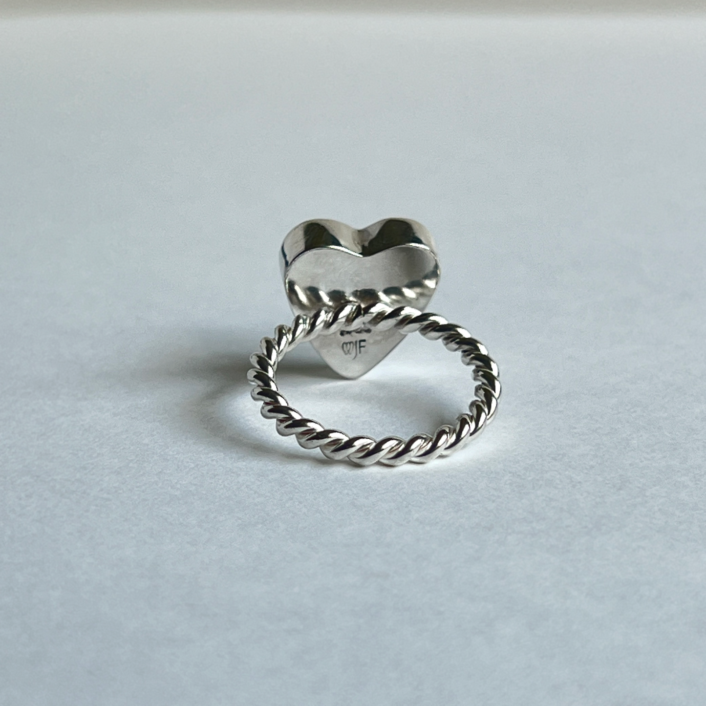 Under bezel view of maker's mark stamped in silver heart ring