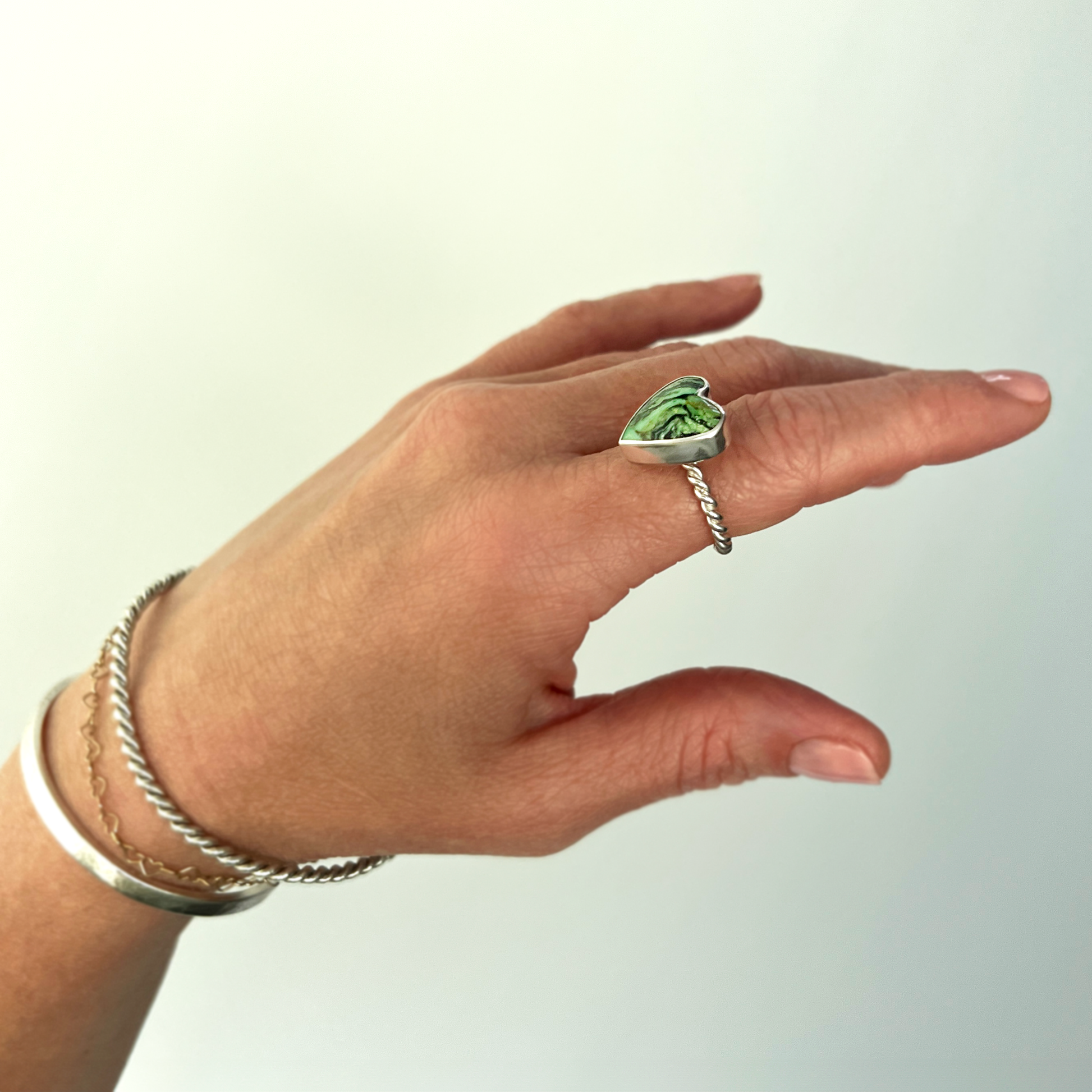 Green turquoise heart and sterling silver ring on hand